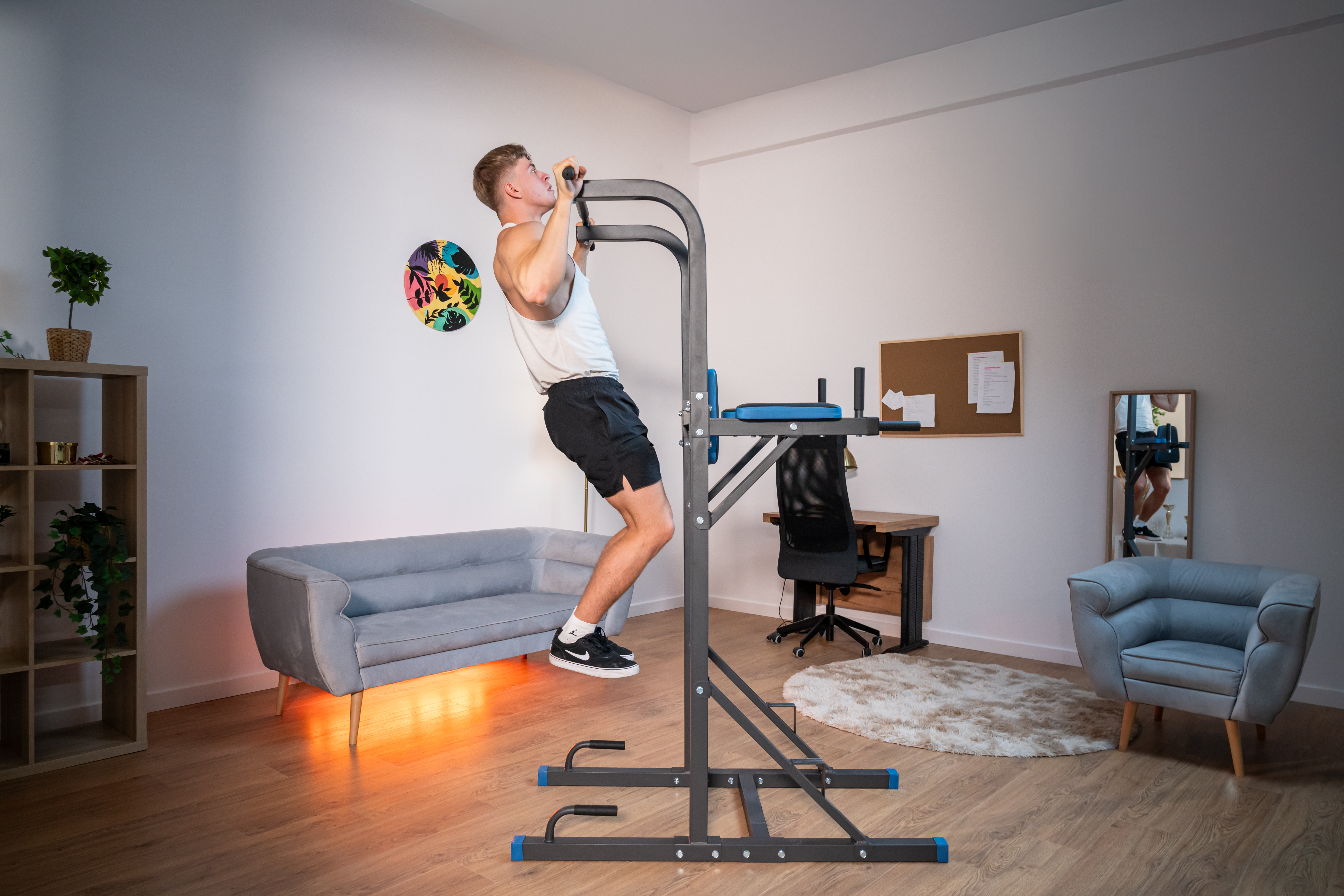 Moteris sportuoja su hanteliais šviesiame kambaryje